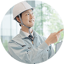 図面を確認しながら指差し確認を行うヘルメット姿の作業員