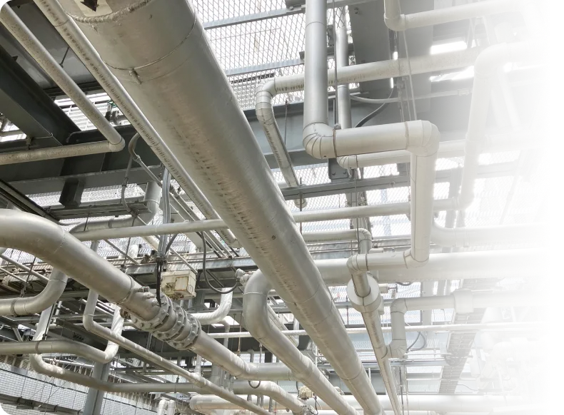 工場内に張り巡らされた配管設備とダクトの様子