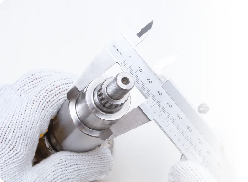 ノギスで金属部品を測定する精密加工の様子