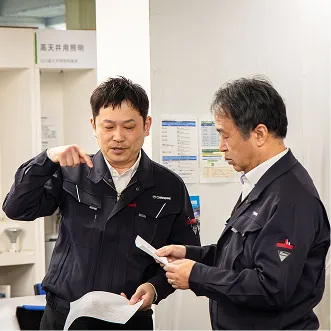 資料を確認しながら打ち合わせを行う社員