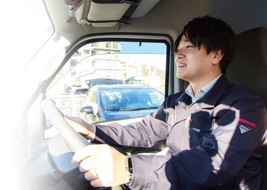 社用車を運転し現場へ向かう社員