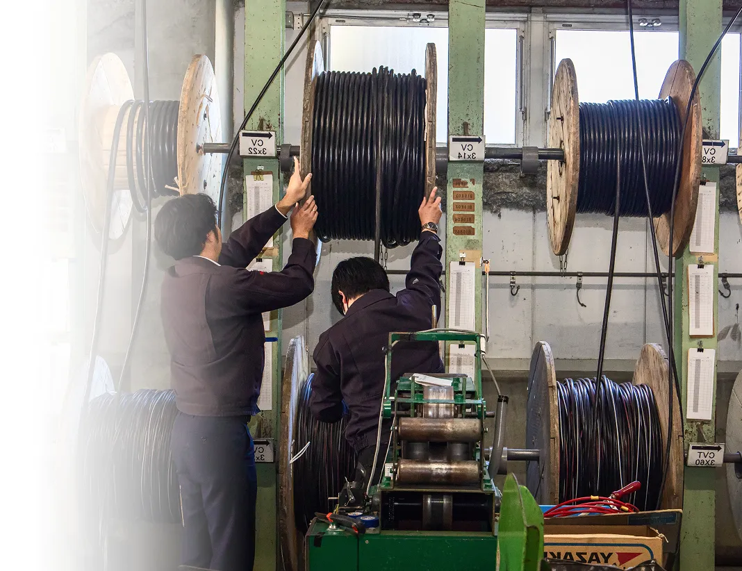 倉庫で電線ケーブルの在庫を確認する社員