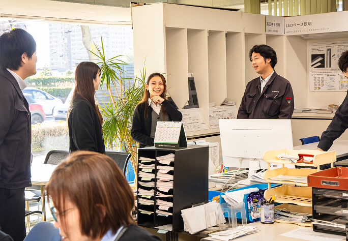 オフィスで談笑しながら仕事をする若手社員