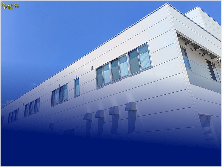 青空の下に建つ白いオフィスビルの外観